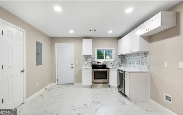a kitchen with stainless steel appliances granite countertop a stove and a refrigerator