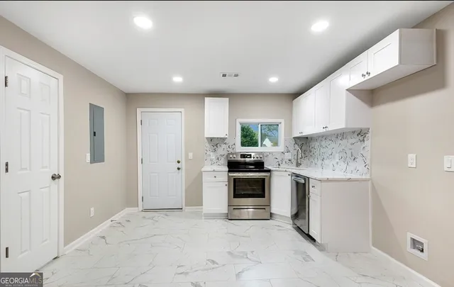 a kitchen with stainless steel appliances granite countertop a stove and a refrigerator