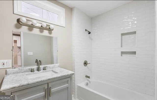 a bathroom with a granite countertop sink and a mirror