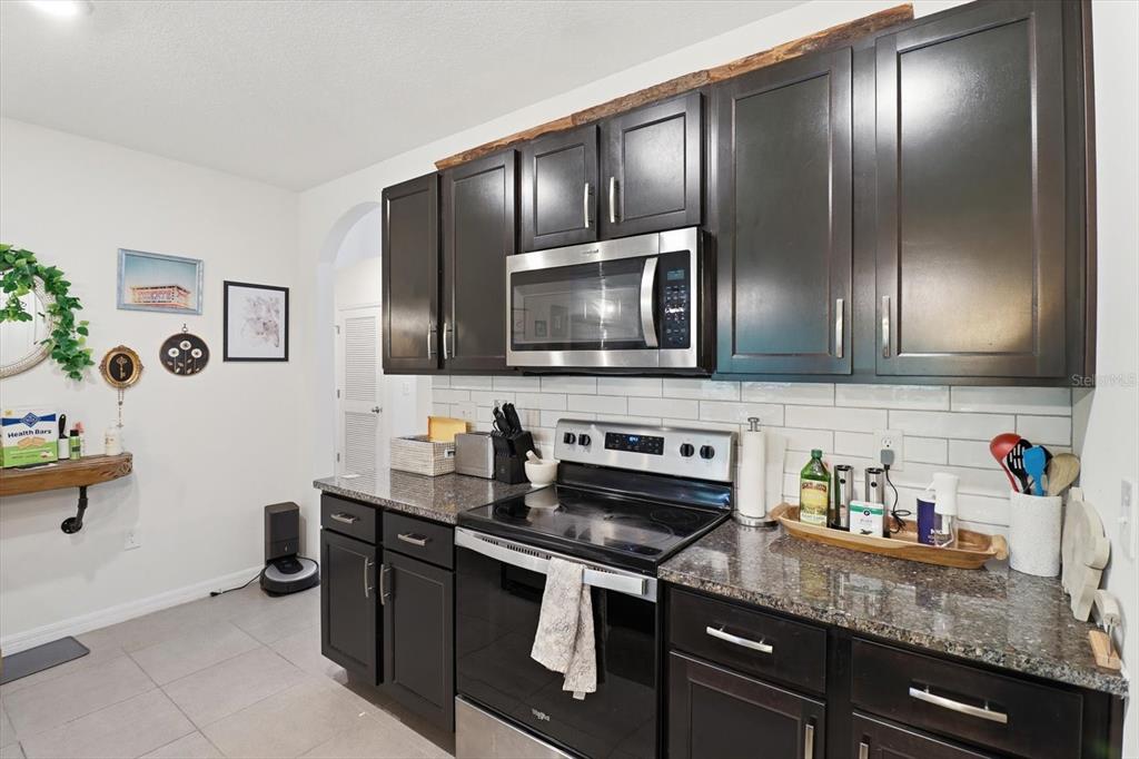 660 Hickory Course Loop Ocala, FL 34472 - Photo 11 of 45 a kitchen with stainless steel appliances granite countertop a sink stove and microwave