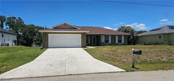 a front view of a house with a yard and garage