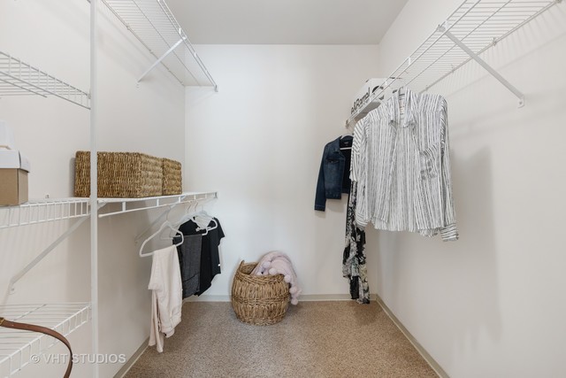 53 Kensington Circle, Unit 106 Wheaton, IL 60189 - Photo 17 of 36 a view of walk in closet with clothes and shoes