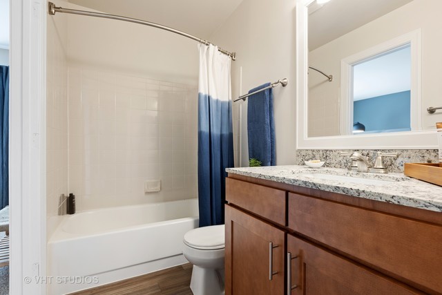 53 Kensington Circle, Unit 106 Wheaton, IL 60189 - Photo 23 of 36 a bathroom with a granite countertop sink toilet and shower
