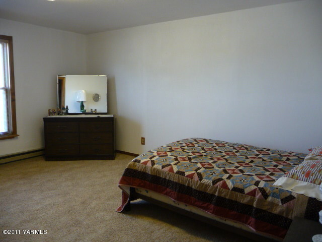 9810 Mieras Road Yakima, WA 98901 - Photo 14 of 16 a bedroom with a bed and dresser