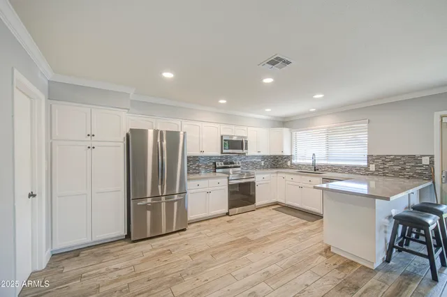 a kitchen with stainless steel appliances granite countertop a refrigerator and a stove top oven
