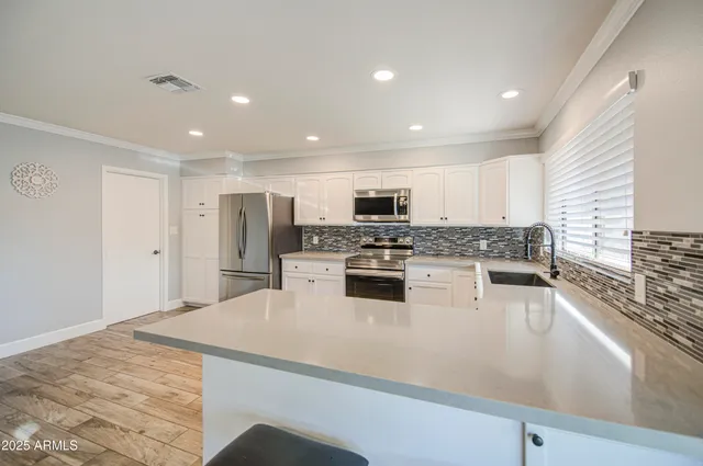 a kitchen with stainless steel appliances a refrigerator sink stove microwave and cabinets
