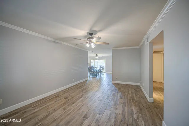 a view of a livingroom with wooden floor and a ceiling fan