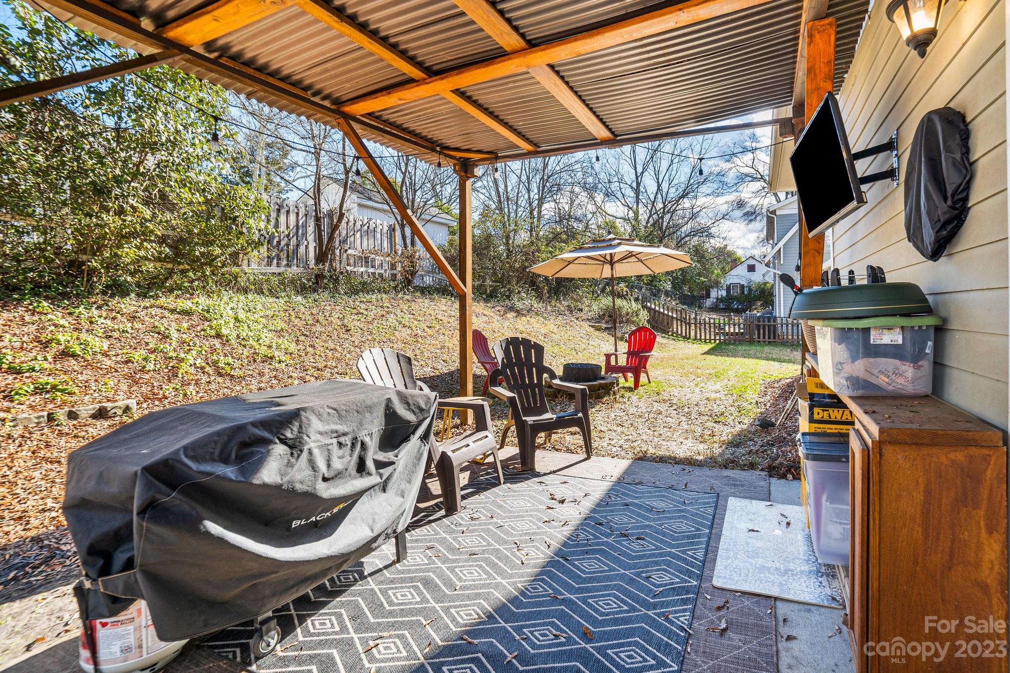 152 Mock Road Davidson, NC 28036 - Photo 27 of 29 a view of a patio with table and chairs under an umbrella with a barbeque