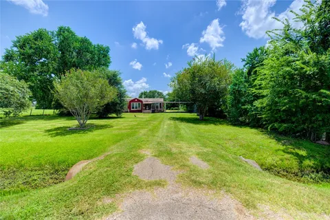 a view of house with a backyard