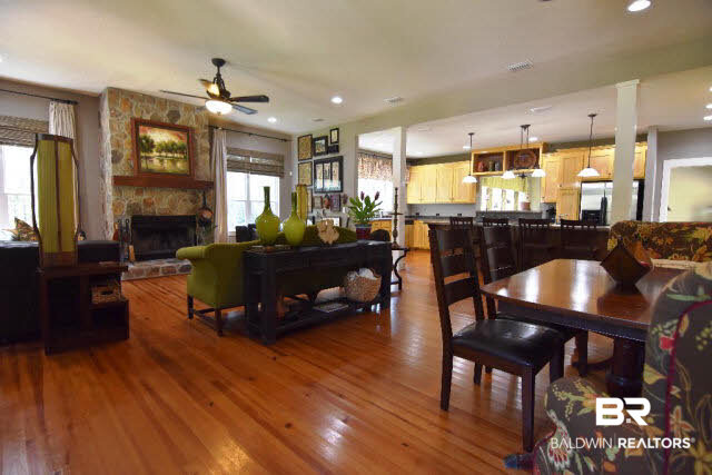 13848 Elmwood Court Stapleton, AL 36578 - Photo 27 of 27 Cozy wood fireplace with tall windows overlooking beautiful trees and stocked pond. Floor plan is very versatile with formal dining area and spacious kitchen with relaxed dining area.
