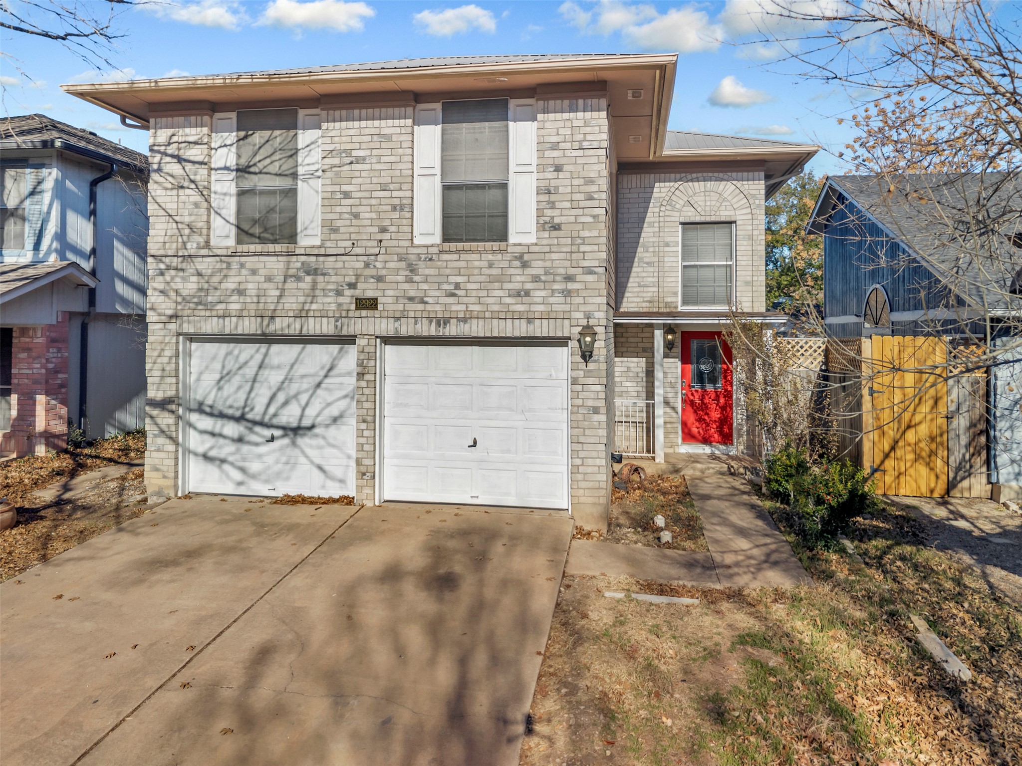 View of front of house with driveway, brick siding, and an attached garage