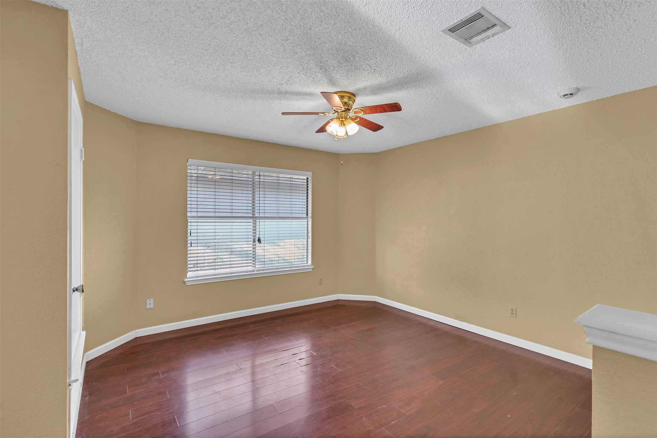 12922 Marimba Trail Austin, TX 78729 - Photo 20 of 28 Unfurnished room with dark wood finished floors, ceiling fan, and a textured ceiling