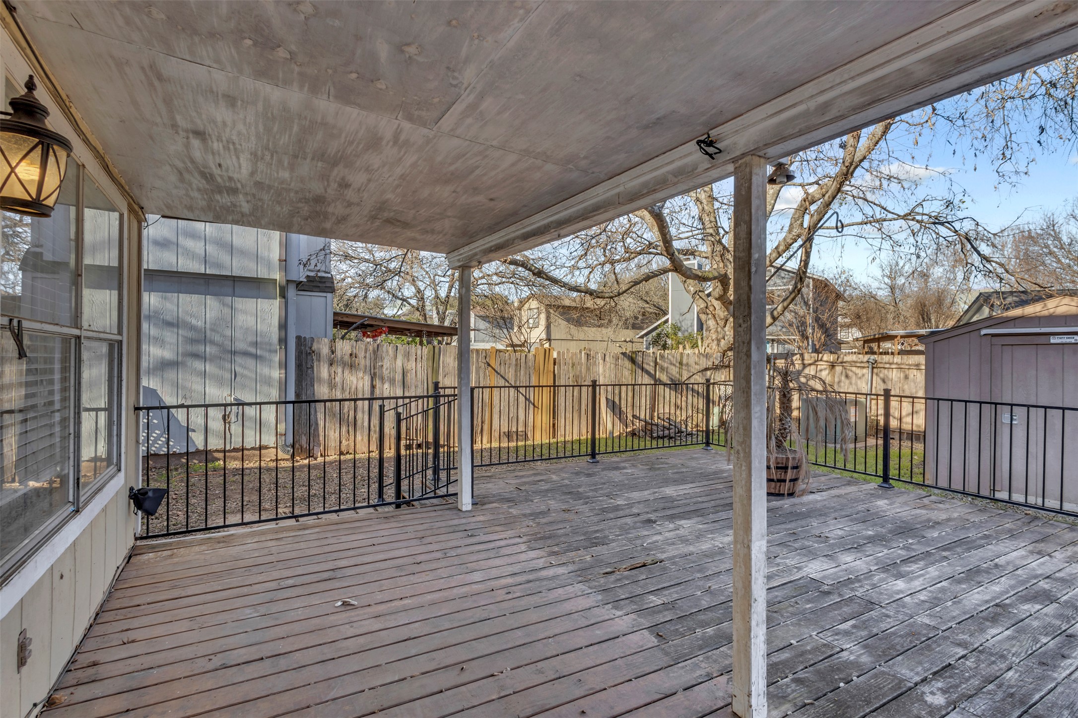 12922 Marimba Trail Austin, TX 78729 - Photo 23 of 28 Wooden terrace featuring a fenced backyard and a storage shed