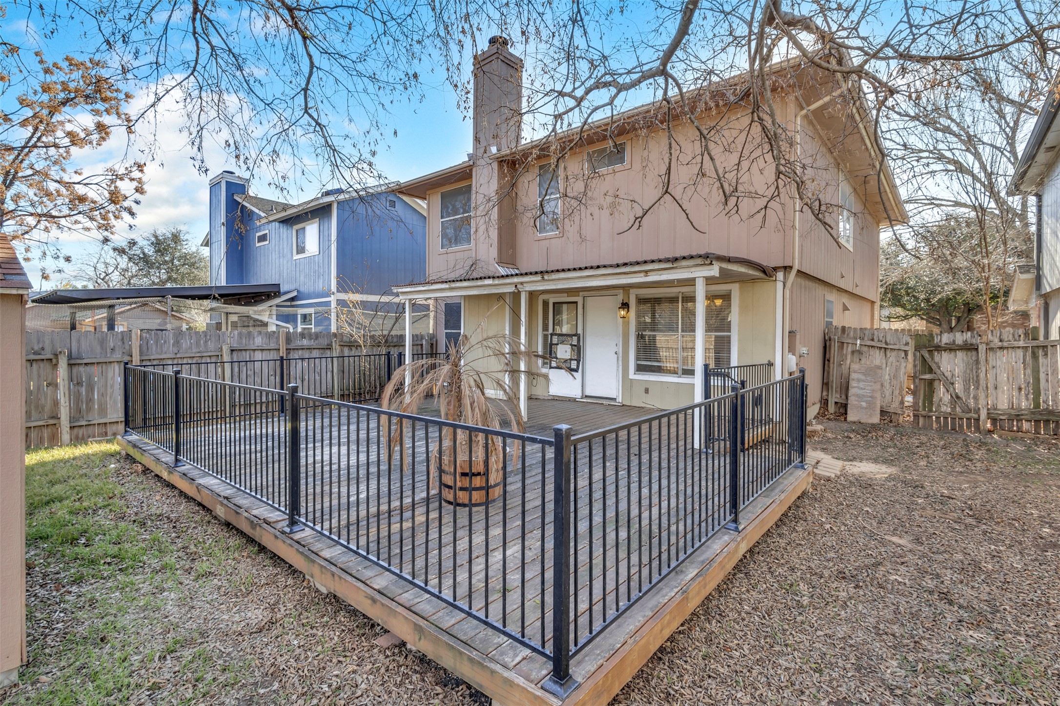 12922 Marimba Trail Austin, TX 78729 - Photo 24 of 28 Rear view of property with a chimney, a fenced backyard, and a deck