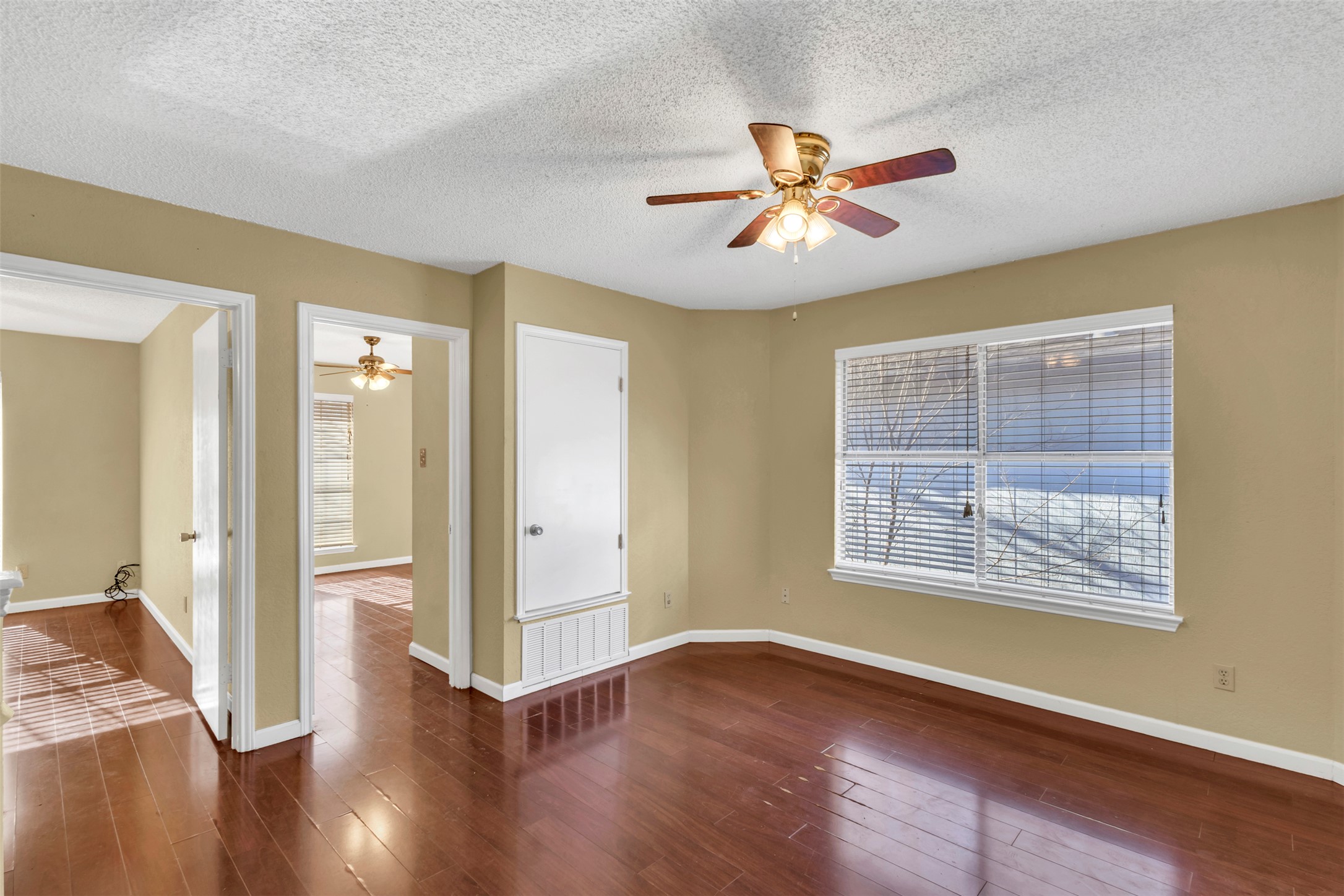 12922 Marimba Trail Austin, TX 78729 - Photo 9 of 28 Unfurnished room featuring ceiling fan, dark wood-style floors, and a textured ceiling