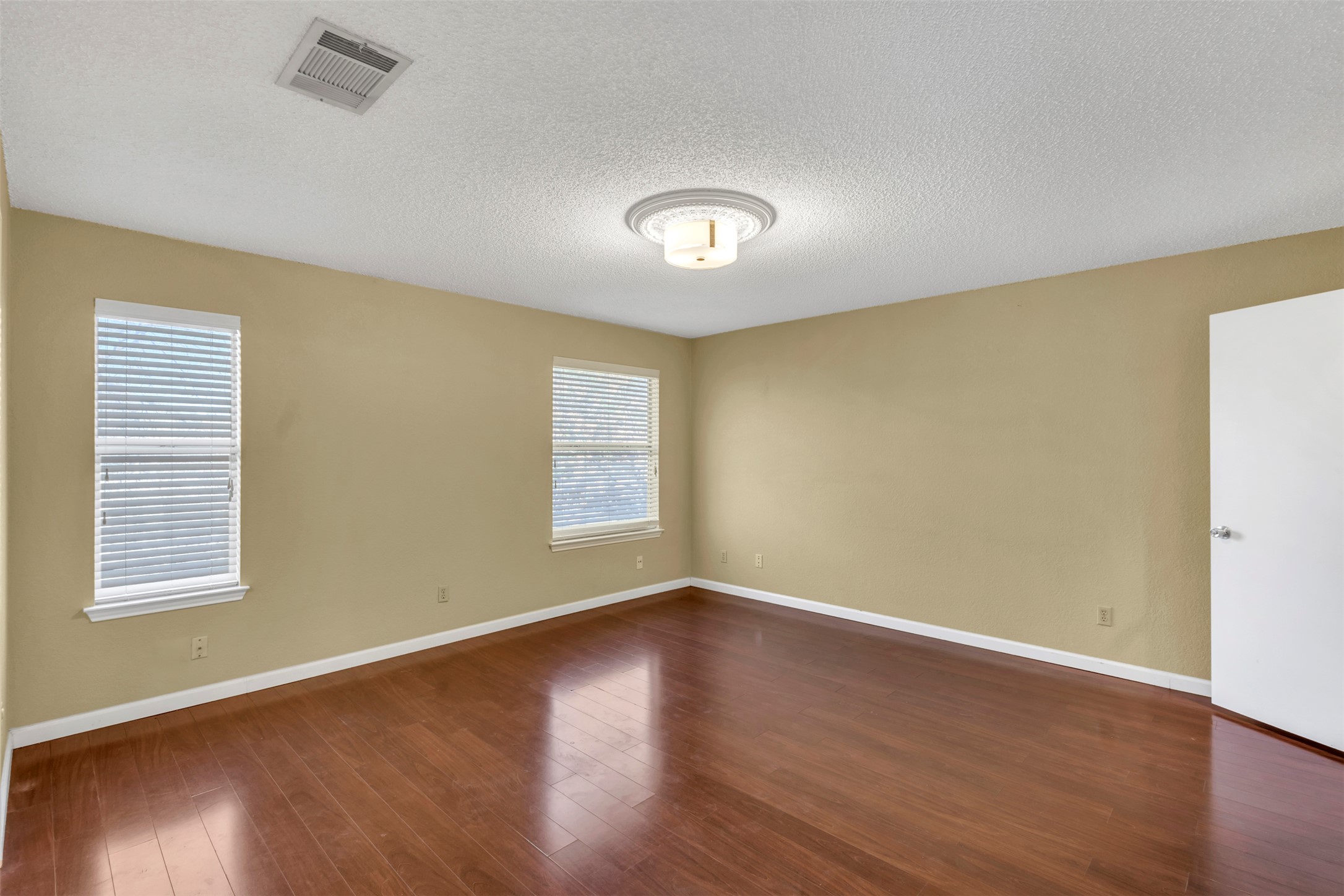 12922 Marimba Trail Austin, TX 78729 - Photo 10 of 28 Spare room with a textured ceiling and dark wood-style flooring