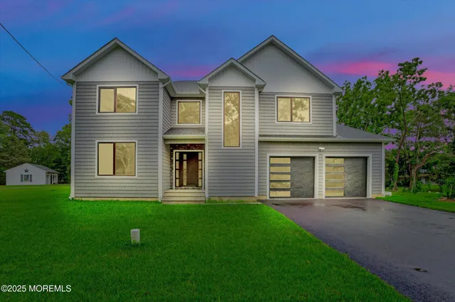 a view of a house with a yard and large tree