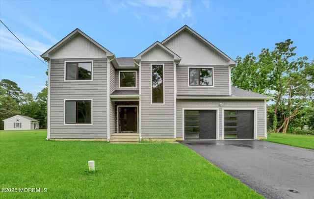 a front view of a house with a yard and trees