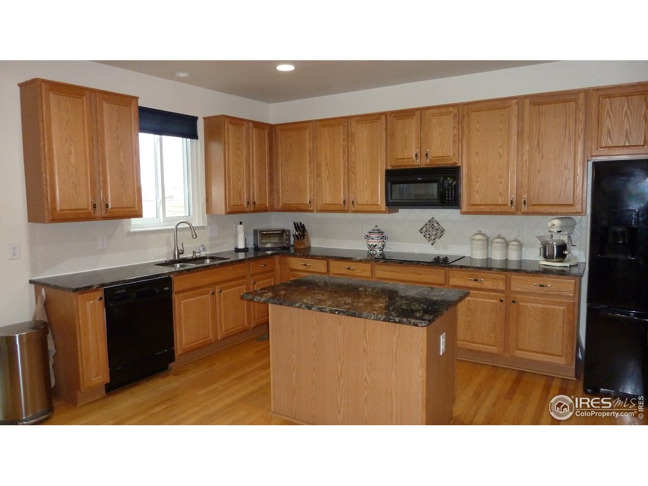 8121 Raspberry Drive Frederick, CO 80504 - Photo 2 of 38 a kitchen with stainless steel appliances granite countertop a stove a sink dishwasher and a microwave oven with cabinets