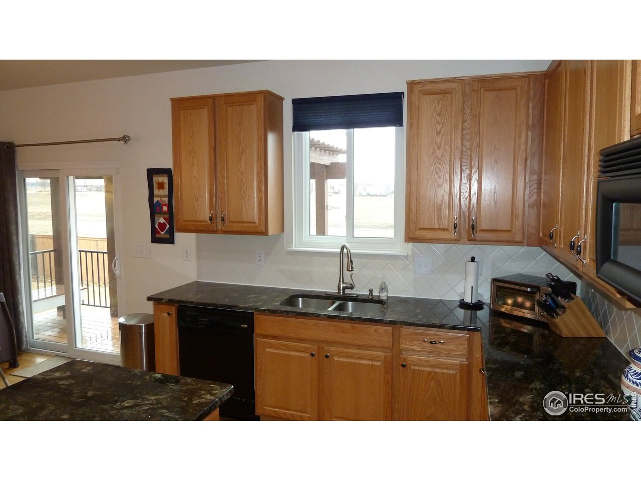 8121 Raspberry Drive Frederick, CO 80504 - Photo 3 of 38 a kitchen with granite countertop stainless steel appliances a sink stove and cabinets