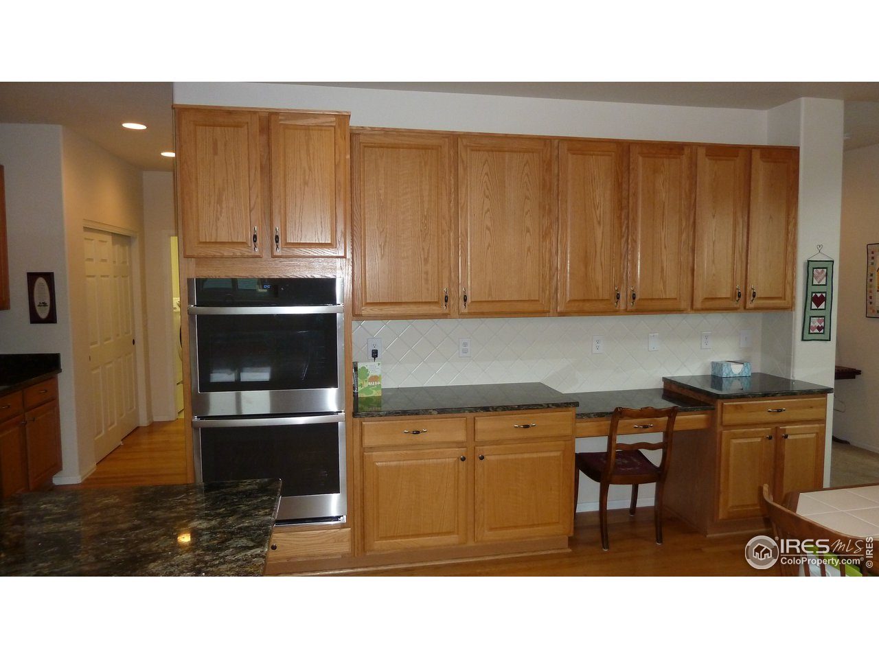 8121 Raspberry Drive Frederick, CO 80504 - Photo 6 of 38 a kitchen with stainless steel appliances kitchen island granite countertop a refrigerator and cabinets