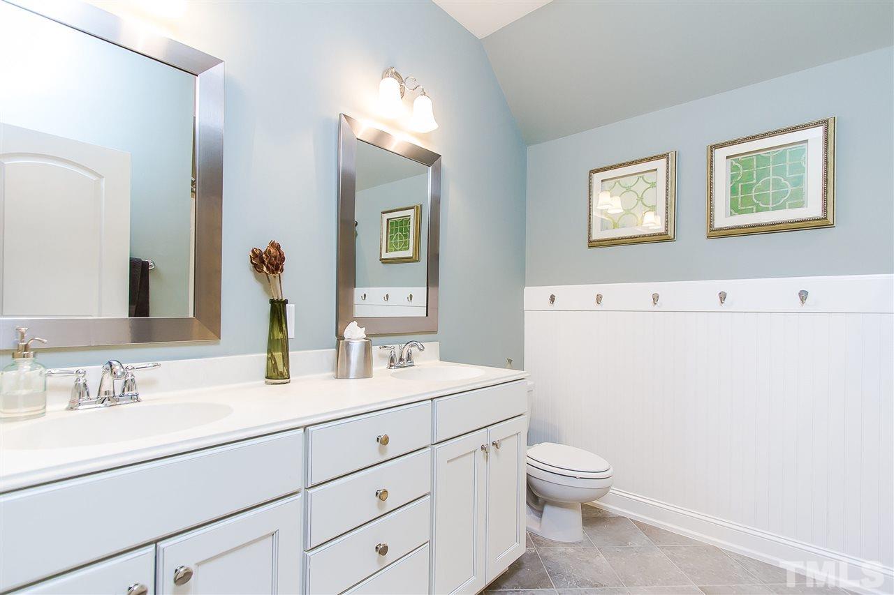 2804 Romealia Lane Raleigh, NC 27613 - Photo 21 of 25 a bathroom with a granite countertop toilet a sink and a mirror