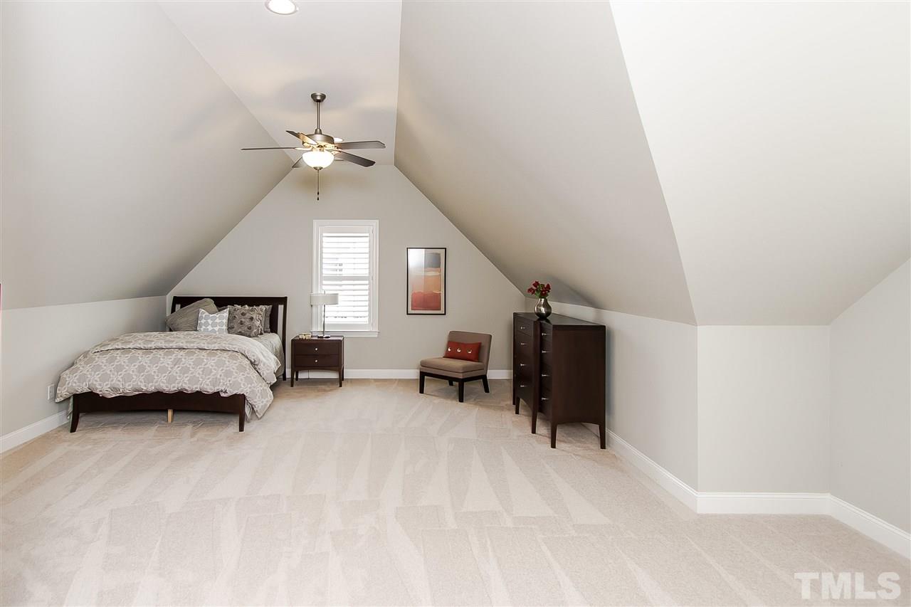 2804 Romealia Lane Raleigh, NC 27613 - Photo 23 of 25 a spacious bedroom with a bed and a chandelier