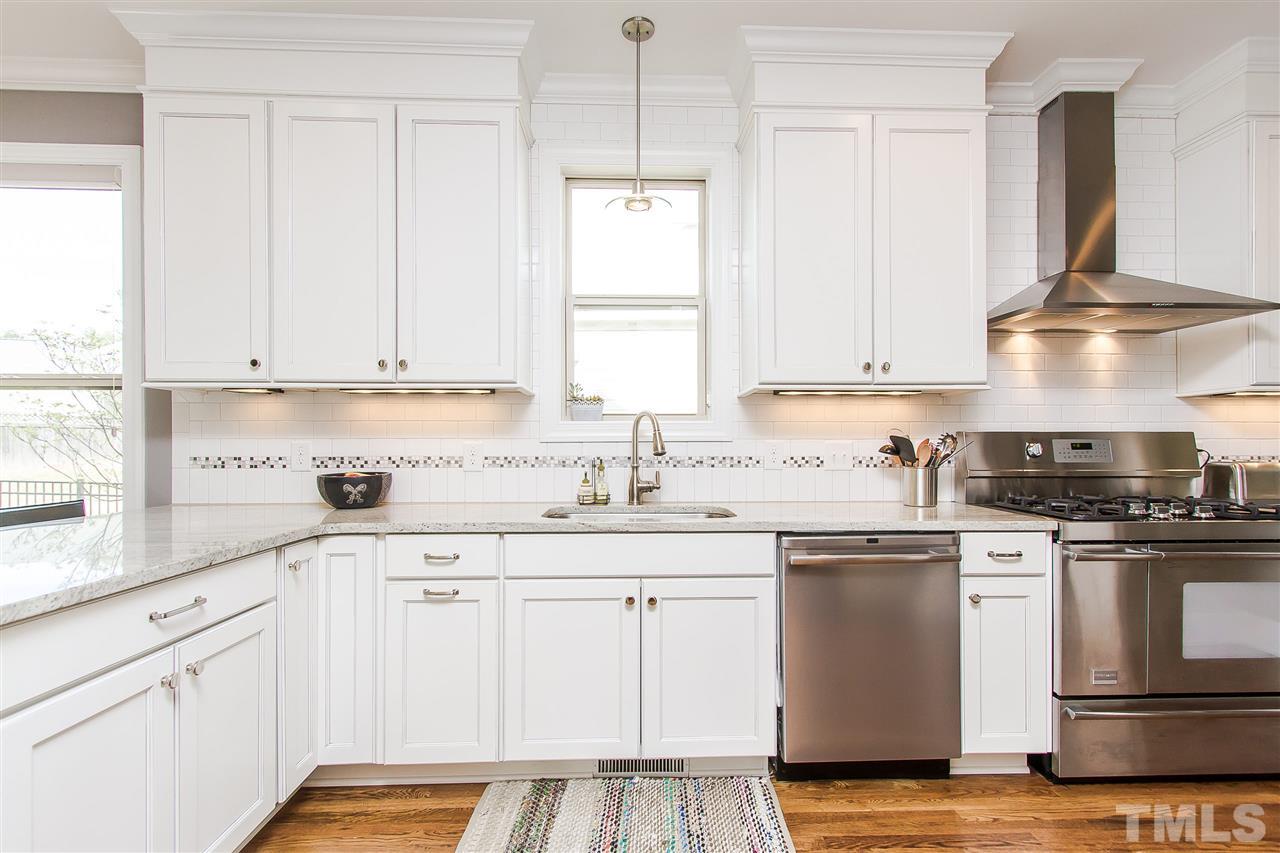 2804 Romealia Lane Raleigh, NC 27613 - Photo 6 of 25 a kitchen with granite countertop white cabinets and white appliances