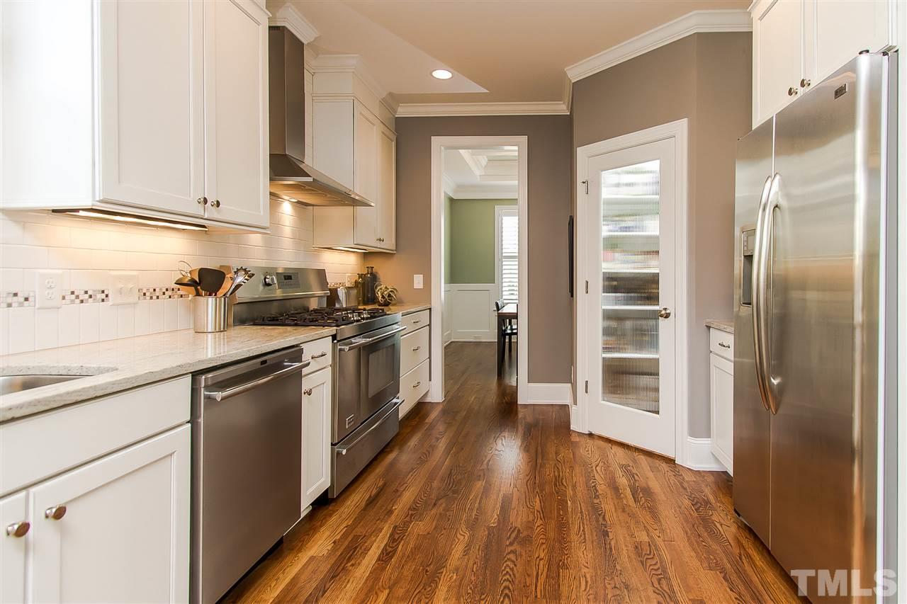 2804 Romealia Lane Raleigh, NC 27613 - Photo 7 of 25 a kitchen with a sink a counter top space stainless steel appliances and cabinets