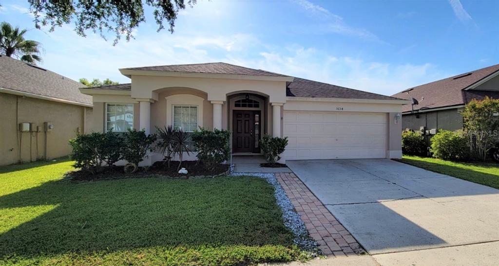 5654 Grindstone Loop Wesley Chapel, FL 33544 - Photo 1 of 1 a front view of a house with a garden