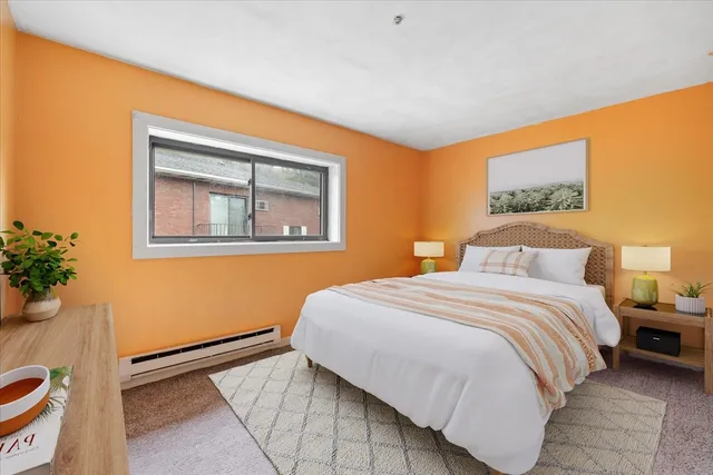 a bedroom with a bed and a painting on the wall