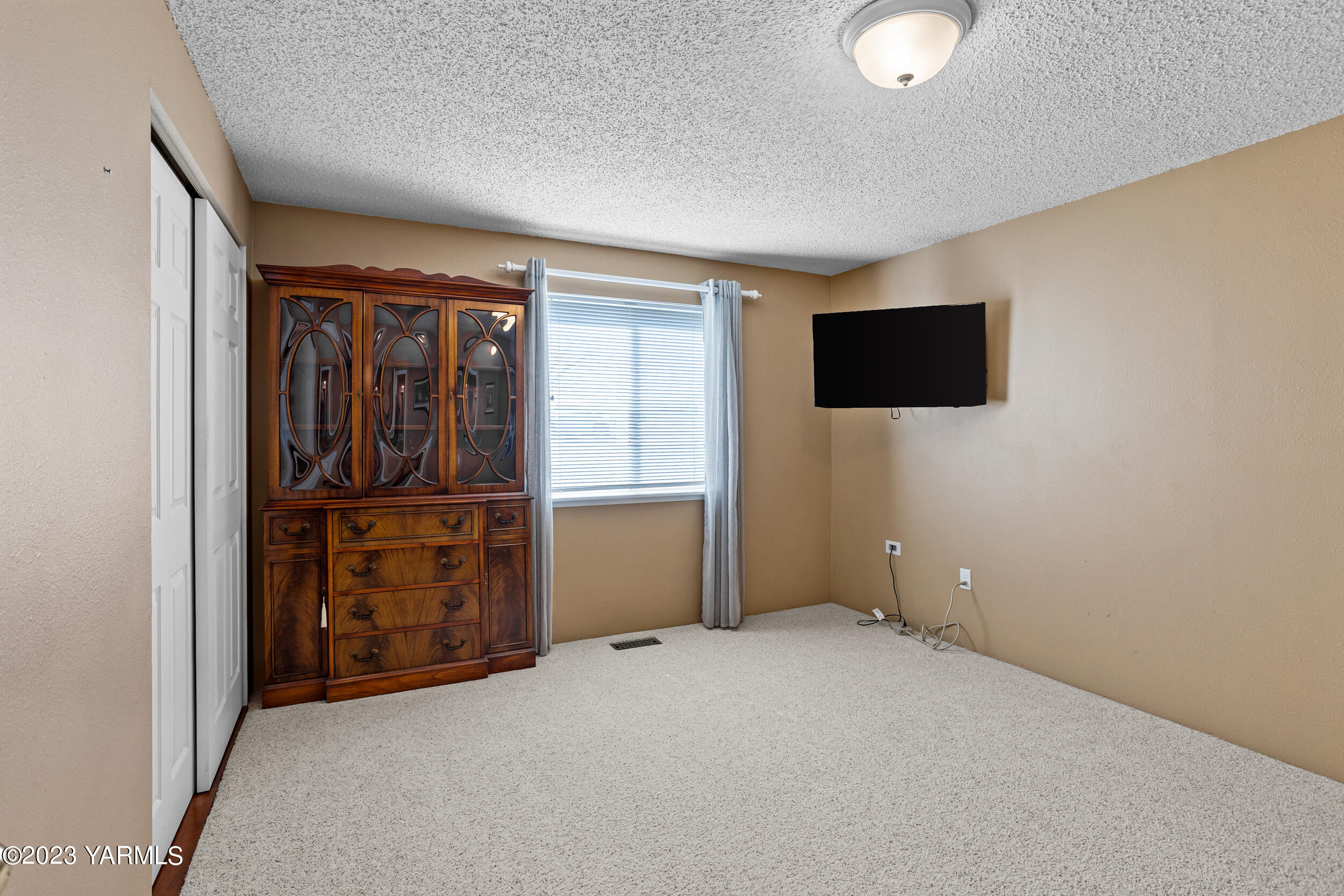 13518 Fisk Road Yakima, WA 98908 - Photo 23 of 58 an empty room with cabinet flat screen tv and refrigerator