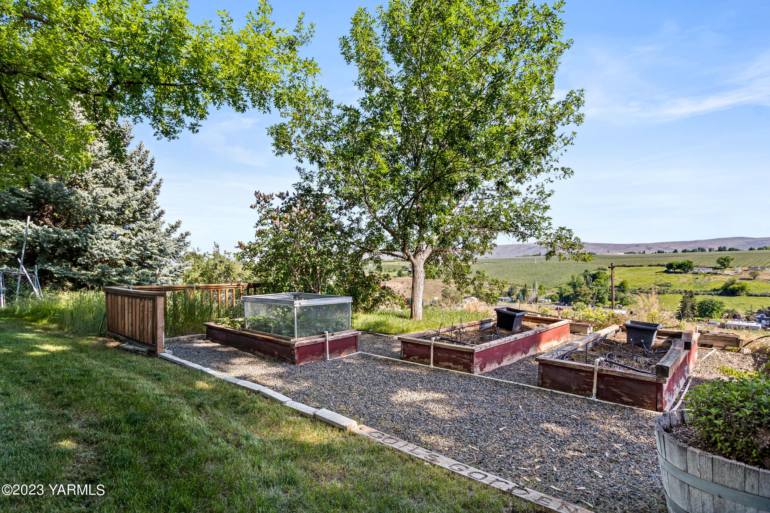 13518 Fisk Road Yakima, WA 98908 - Photo 49 of 58 a view of a patio with table and chairs potted plants and a large tree