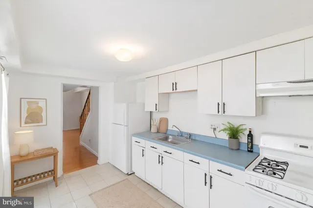 a kitchen with granite countertop white cabinets and white appliances