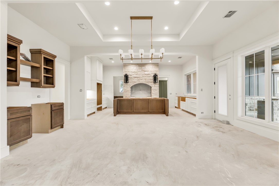 1141 Bluebonnet Ridge Drive Chappell Hill, TX 77426 - Photo 5 of 32 an empty room with chandelier fan and kitchen view