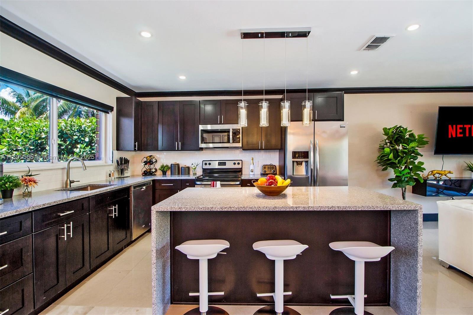 11975 West Biscayne Canal Road Miami, FL 33161 - Photo 30 of 58 a kitchen with stainless steel appliances granite countertop a sink counter space and cabinets