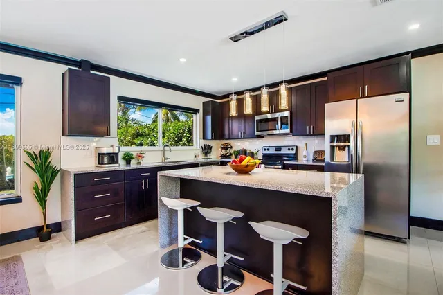 a kitchen with stainless steel appliances granite countertop a sink stove and refrigerator