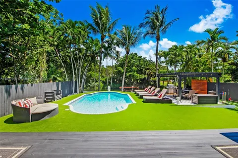 a view of a backyard with swimming pool and furniture