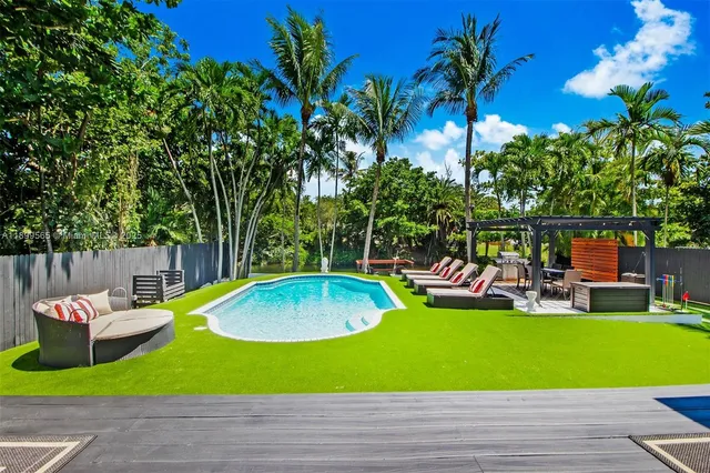 a view of a backyard with swimming pool and furniture