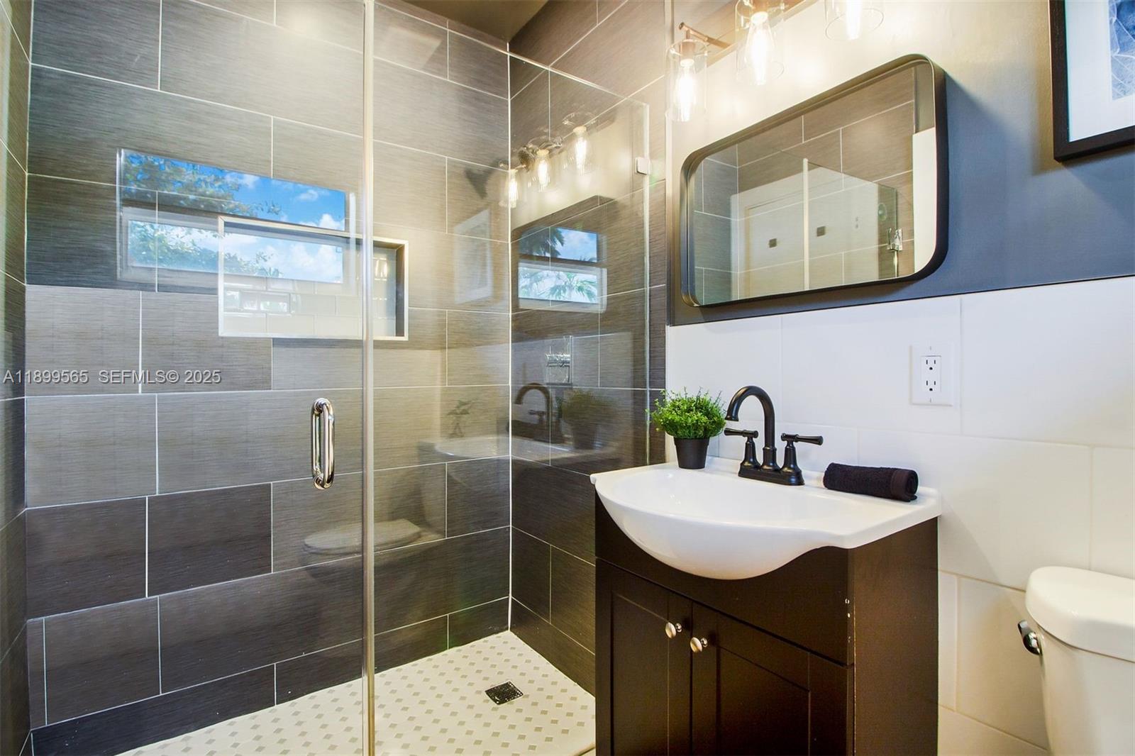 11975 West Biscayne Canal Road Miami, FL 33161 - Photo 41 of 58 a bathroom with a sink mirror and toilet