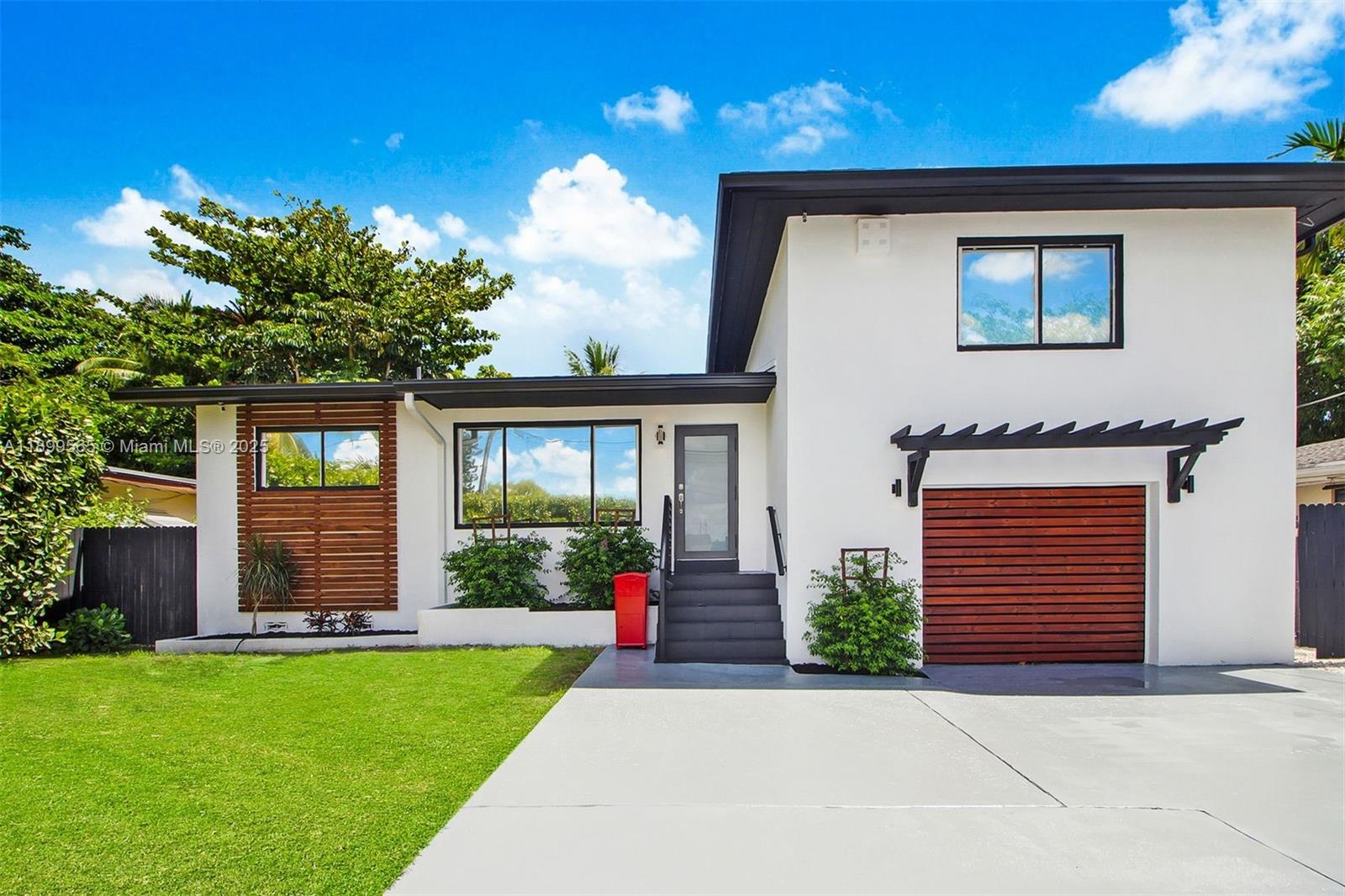11975 West Biscayne Canal Road Miami, FL 33161 - Photo 5 of 58 a front view of a house with a yard and garage