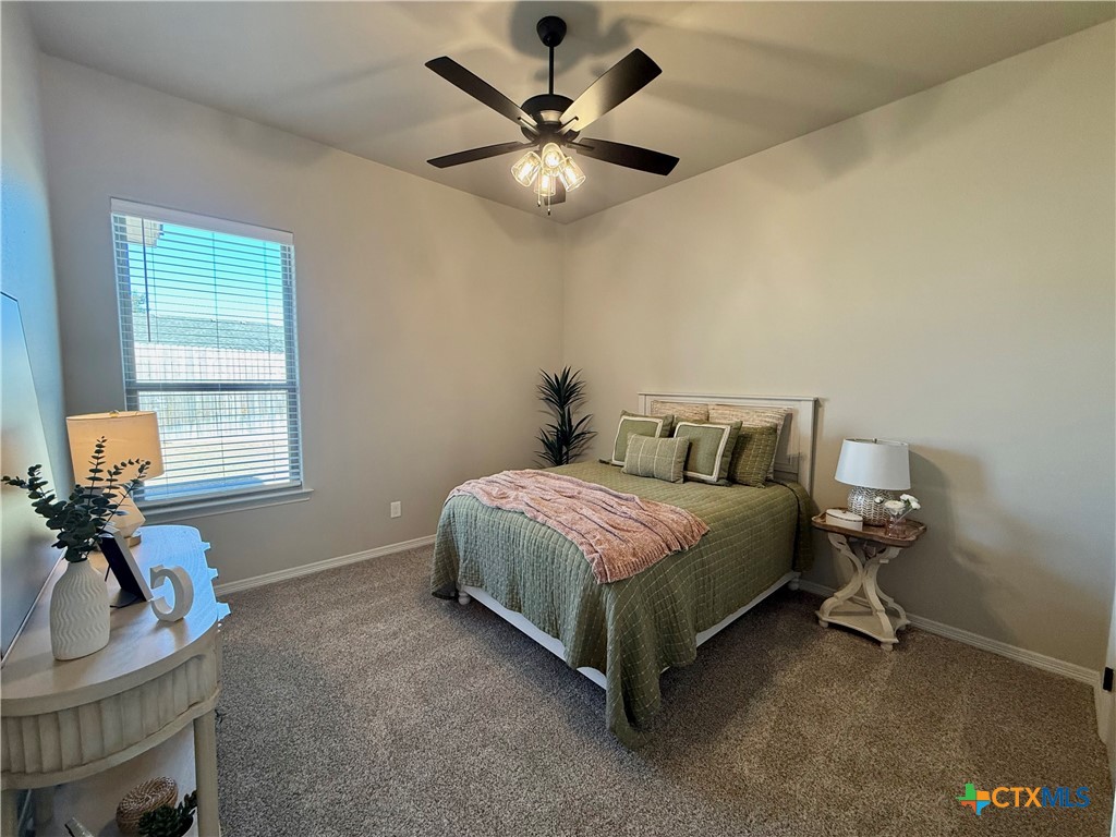 203 Lasso Loop Lorena, TX 76655 - Photo 20 of 36 a bedroom with a bed and a chandelier