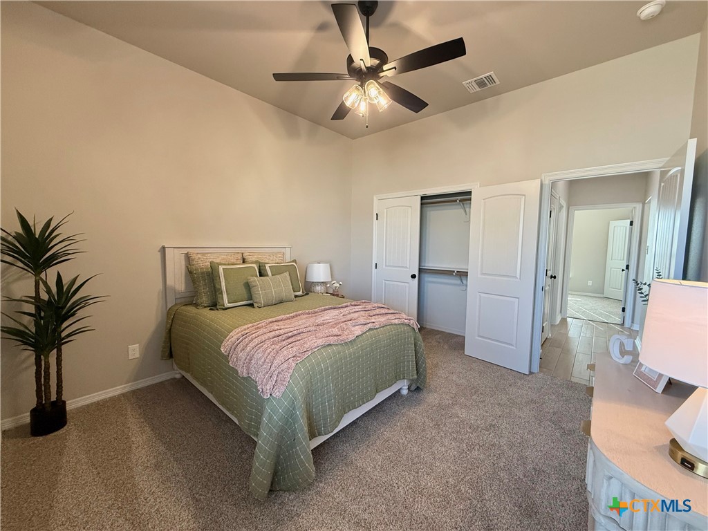 203 Lasso Loop Lorena, TX 76655 - Photo 21 of 36 a bedroom with a bed and a chandelier