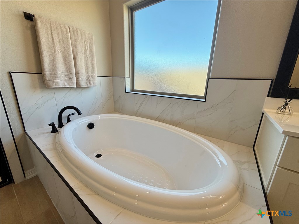 203 Lasso Loop Lorena, TX 76655 - Photo 26 of 36 a bathroom with a bathtub and a sink