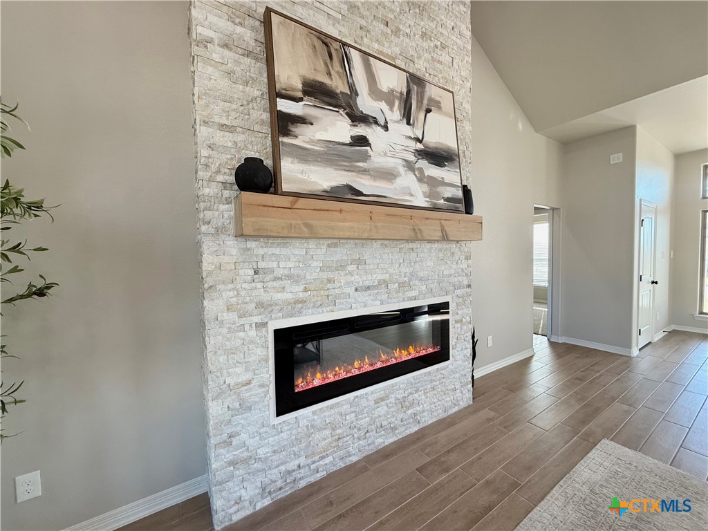 203 Lasso Loop Lorena, TX 76655 - Photo 8 of 36 a living room with a fireplace and wooden floor