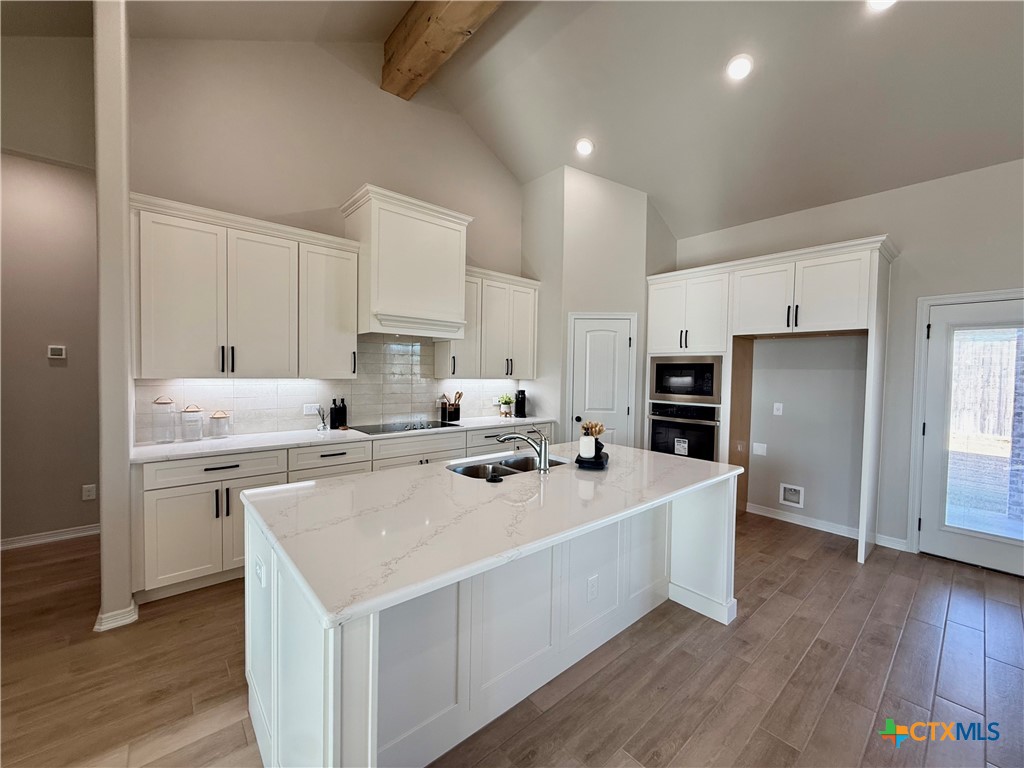 203 Lasso Loop Lorena, TX 76655 - Photo 9 of 36 a kitchen with a sink a stove a refrigerator and white cabinets