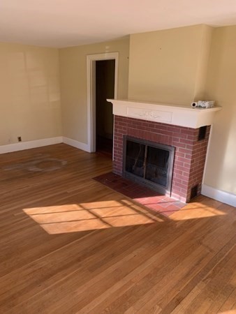 407 High Plain Road Andover, MA 01810 - Photo 21 of 25 a view of empty room with wooden floor and fireplace
