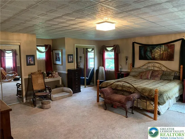 a spacious bedroom with a bed a mirror and furniture