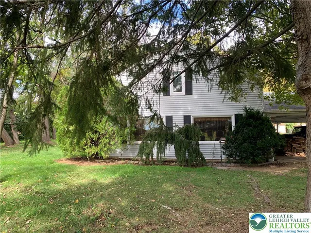 a front view of a house with a tree