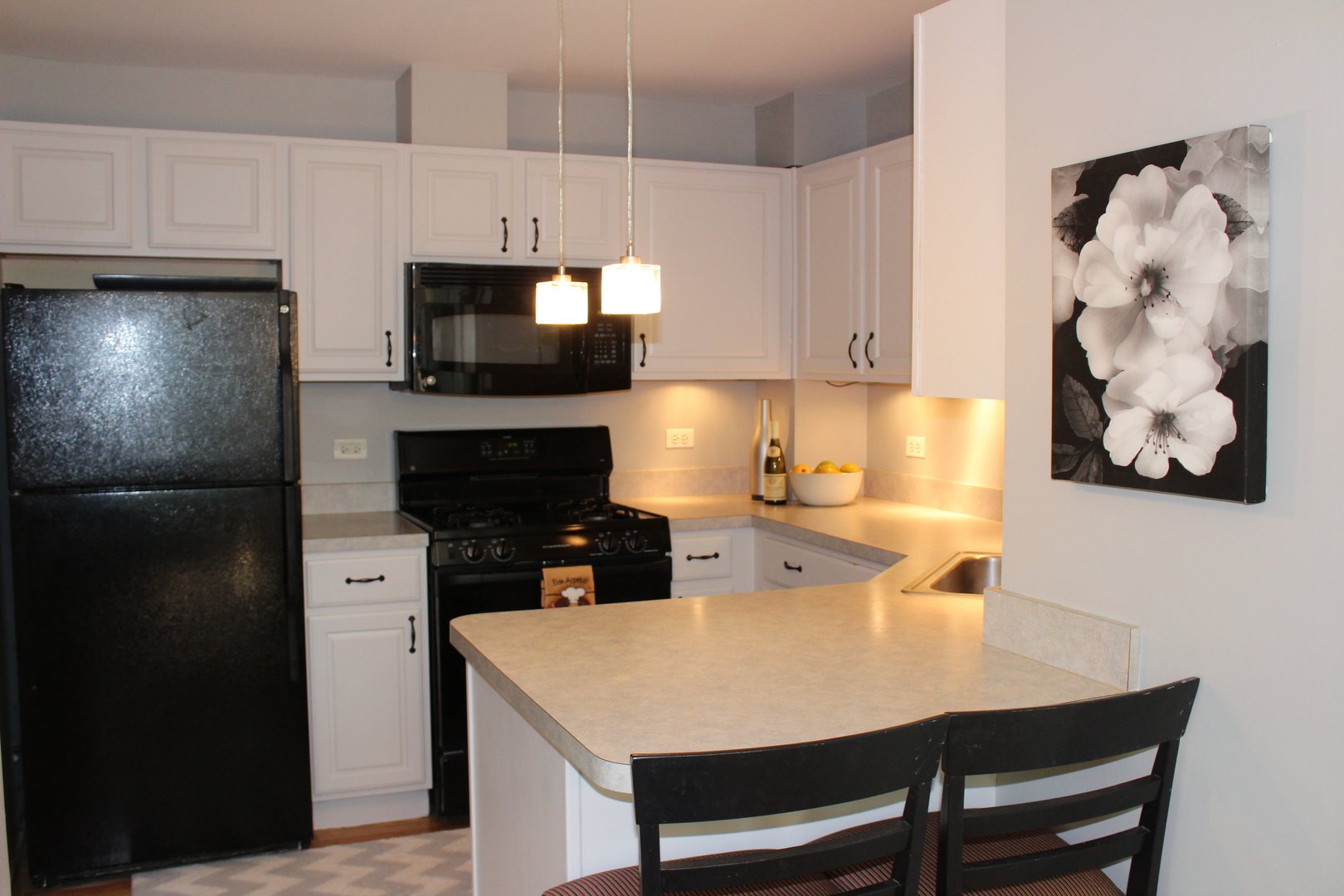 481 River Bend Road, Unit 107 Naperville, IL 60540 - Photo 3 of 17 a kitchen with a sink a microwave a refrigerator and cabinets